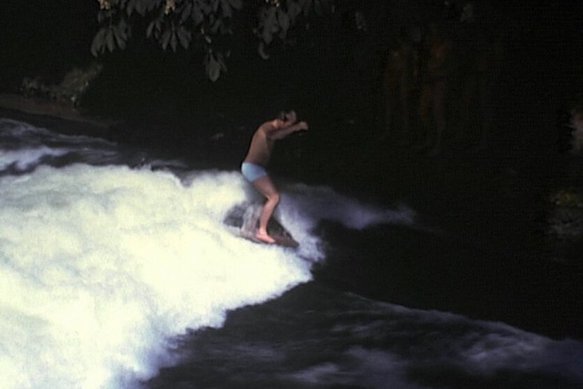 Historische unscharfe Aufnahme von einem Surfer auf einer Flußwelle