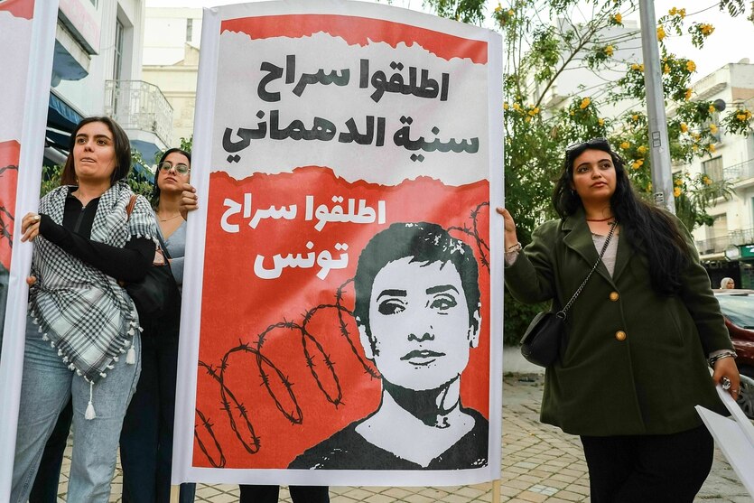 Protestaktion mit einem Plakat, das die Freilassung fordert - auf dem Plakat ist ihr Gesicht vor einem Stacheldraht als Strichzeichnung zu sehen -