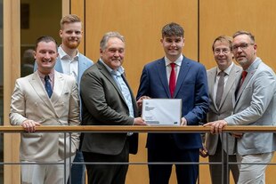 Mehrere Männer halten eine Petition in der Hand