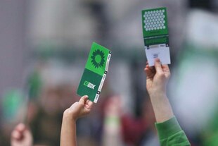 Delegierte halten ihre Stimmkarten hoch