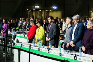 Grüne um Felix Banaszak und Britta Haßelmann stehend während einer Schweigeminute