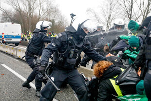 Behelmte Polizisten greifen Demonstriende an