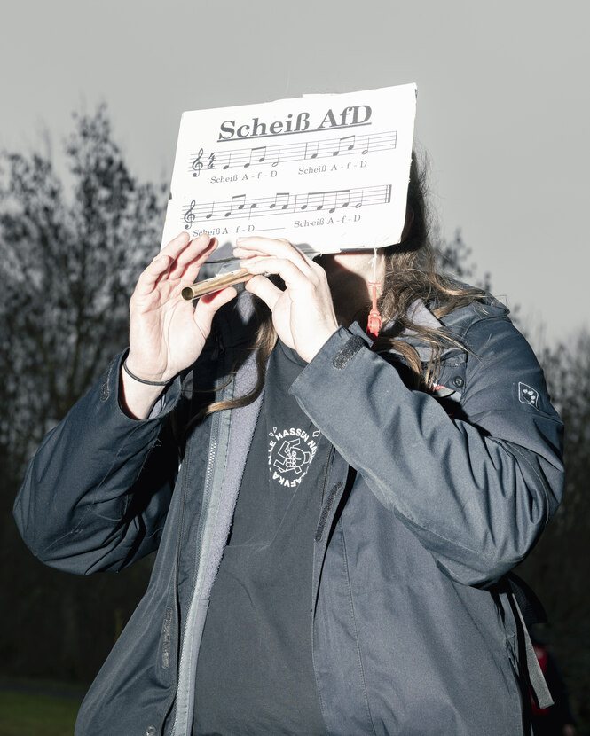 Eine Person spielt bei Protesten gegen die AfD auf einer Flöte