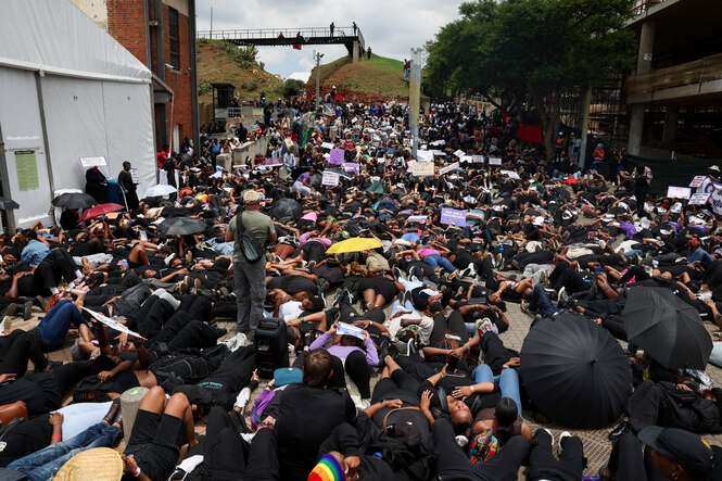 Schwarz gekleidete Menschen liegen als Protest auf dem Boden