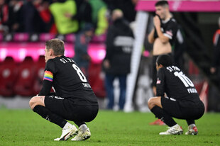 Zwei enttäuschte Spieler in der Hocke auf dem Rasen nach dem Schlusspfiff