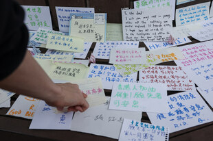 Mit meist auf chinesisch geschriebenen Zetteln drückt Hongkongs Bevölkerung in der Nähe des Brandortes ihre Betroffenheit und ihr Mitgefühl mit den Opfern aus