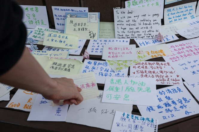 Mit meist auf chinesisch geschriebenen Zetteln drückt Hongkongs Bevölkerung in der Nähe des Brandortes ihre Betroffenheit und ihr Mitgefühl mit den Opfern aus