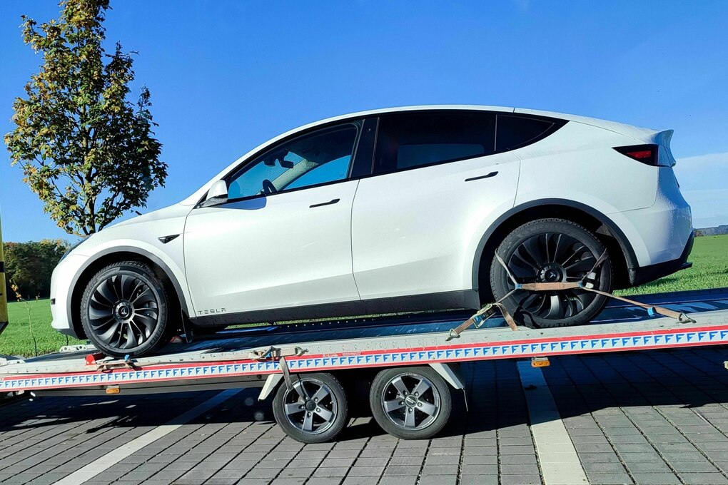 Ein weißer Tesla Y auf einem Abschleppwagen