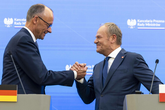 Bundeskanzler Merz und Premierminister Tusk begrüßen sich bei einer Pressekonferenz.