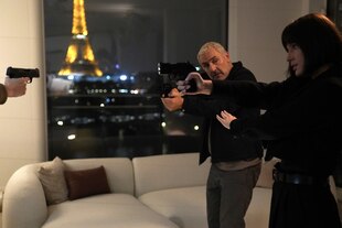 Gilles Lellouche und Adèle Exarchopoulos zielen mit Pistolen in die Richtung einer Pistole, die auf Lellouche gerichtet ist.