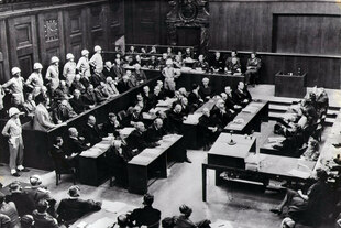 Blick auf die Anklagebank des Internationalen Militärgerichts in Nürnberg 1945: die Regime-Stützen werden von Militärpolizisten mit weißen Helmen bewacht