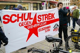 Personen halten ein Protestbanner, auf dem steht: Schulstreik gegen Wehpflicht