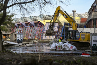 Ein Bagger transportiert Schutt vor der Fassade des Sport- und Erholungszentrums (SEZ)