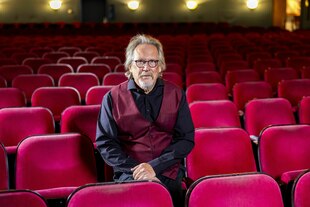 Ein Mann sitzt im Zuschauerraum eines Theaters