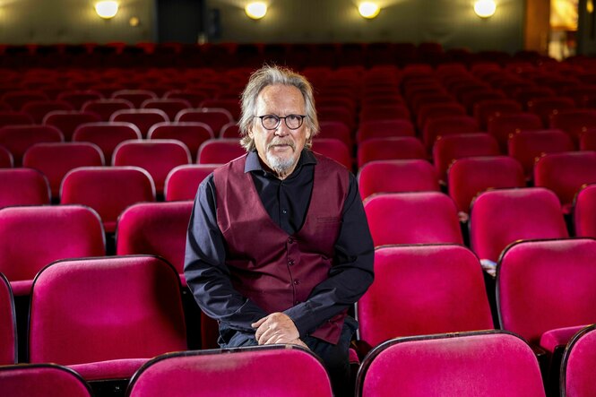 Ein Mann sitzt im Zuschauerraum eines Theaters