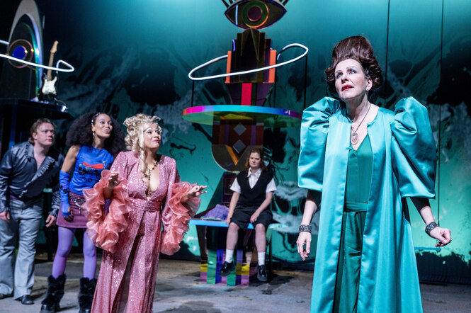 Auf der Bühne stehen fünf sehr unterschiedlich fantasievoll gewandete Frauen und machen etwas exaltierte Gesten