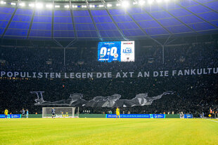 Olympiastadion mit Blick auf die Kurve und einem großen Transparent mit der Aufschrift "Populisten legen die Axt an die Fankultur"