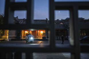 Blick durch ein Gitter auf einen Innenhof, in dem ein Lieferfahrzeug parkt