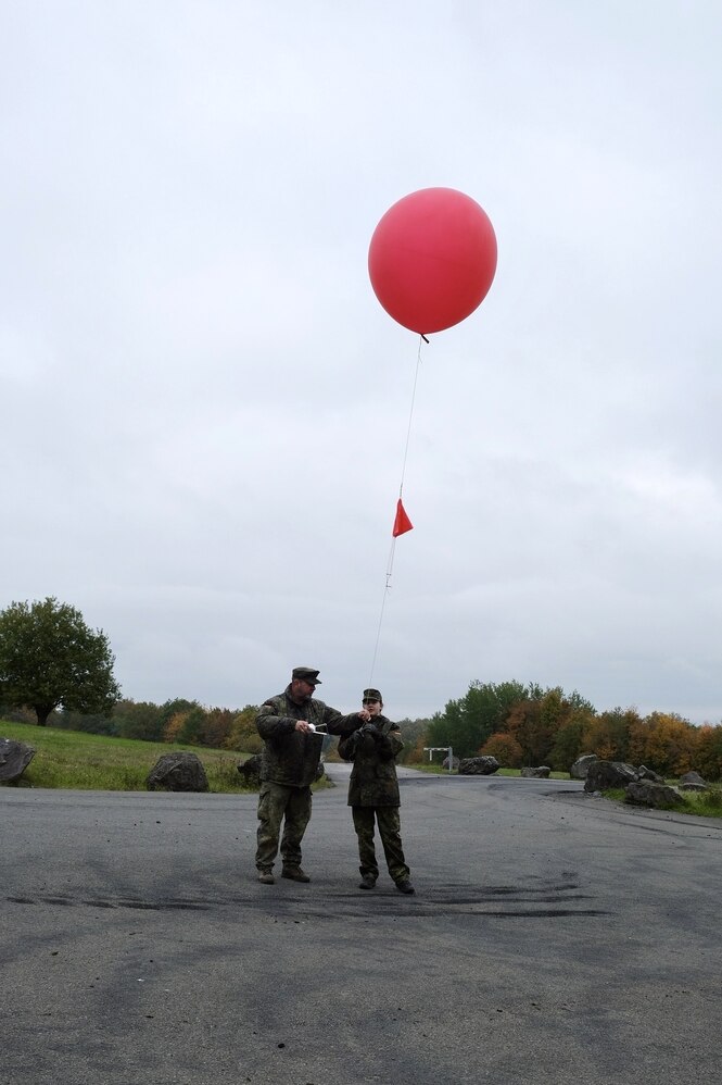 Zwei Männer in Uniform mit einem roten Ballon