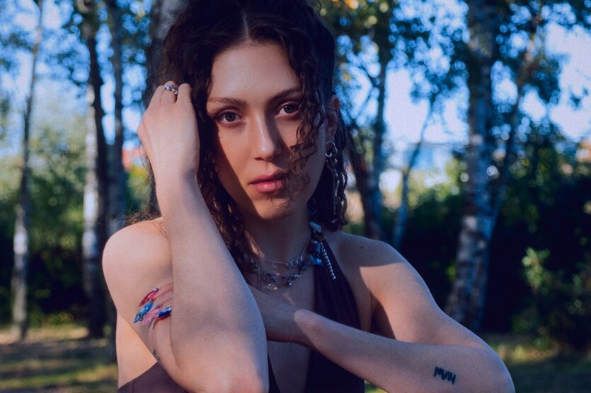 Die Autorin Tia Morgen vor einer sommerlichen Naturkulisse