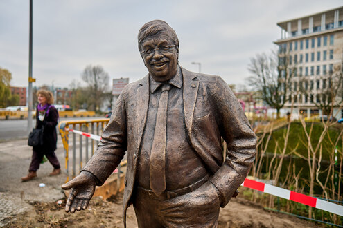 Ein Denkmal in Gestalt von Walter Lübcke vor rot-weißem Flatterband