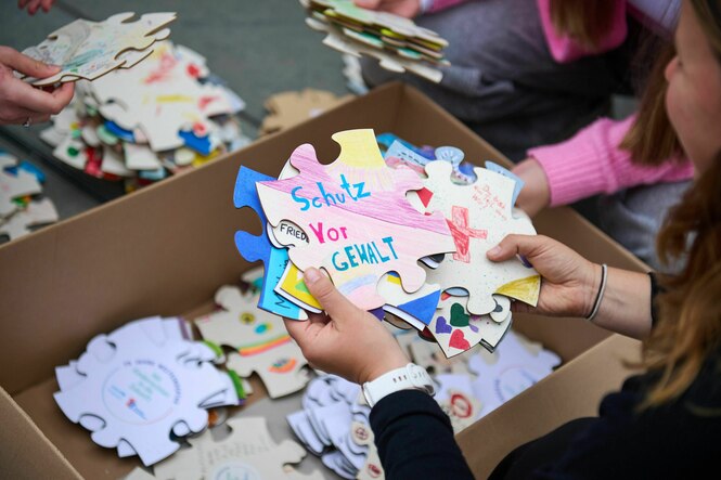 Kinder halten große Puzzleteile in den Händen