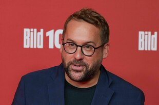 Paul Ronzheimer vor rotem Hintergrund mit "Bild"-Zeitungs-Logo