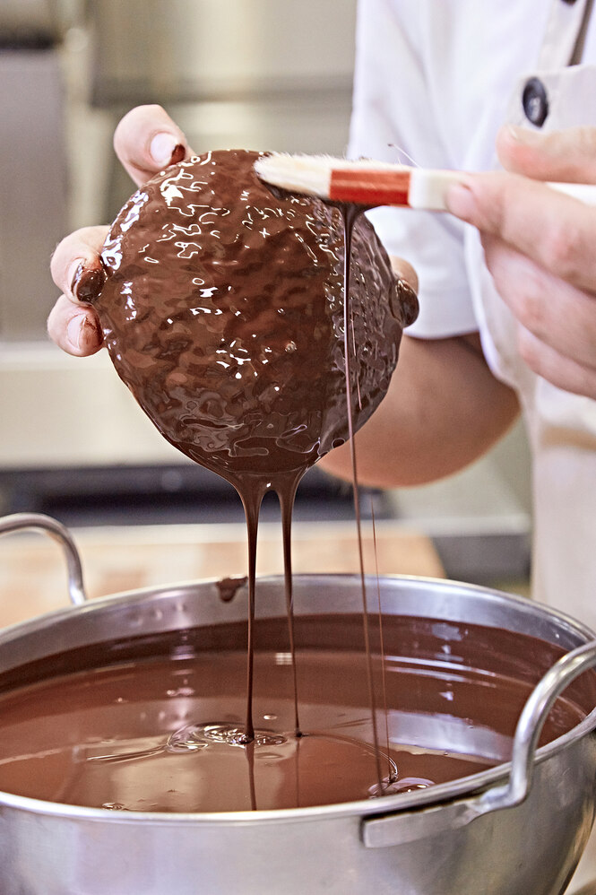 Ein Lebkuchen wird mit flüssiger Schokolade bestrichen