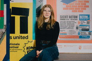 Portrait von Antonia Melzer vor bunten Plakaten