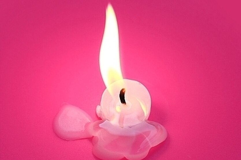 Eine fast abgebrannte Kerze, die im geschmolzenen Wachs steht