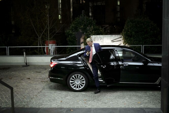 Christian Lindner steigt aus einem schwarzen Auto und schaut auf sein Smartphone, es ist Nacht