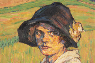 Vor gelben Feldern steht eine etwas grimmig blickende Frau, die ein dünnes, dunkelblaues Glockenhütchen mit Blumenschmuck trägt