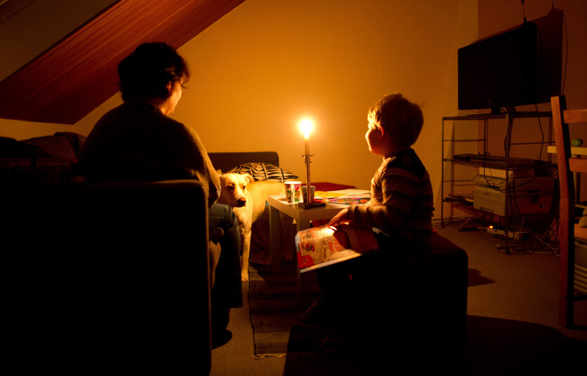 Eine Mutter und ihr Sohn sitzen im Schein einer Kerze in einem Zimmer