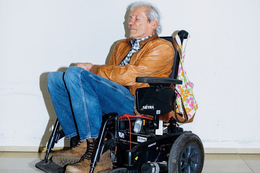 Portrait von Udo Sierck, einem Mann mit hellbrauner Lederjacke, der im Rollstuhl sitzt