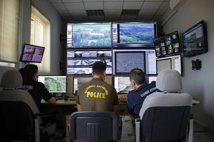 Griechische Grenzschützer und Grenzschützerinnen sitzen vor Computerbildschirmen