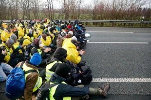 Eine Gruppe Menschen in gelben Westen blockiert eine Autobahn Strasse