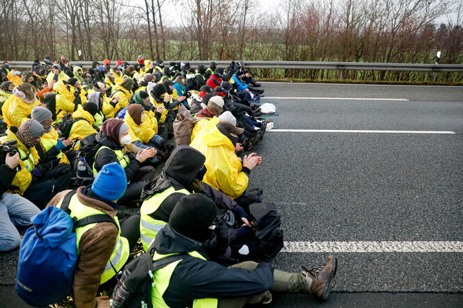 Eine Gruppe Menschen in gelben Westen blockiert eine Autobahn Strasse