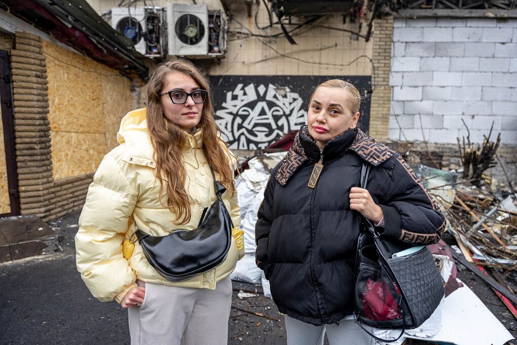 Zwei Frauen stehen vor einem zerstörten Hauseingang