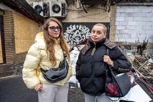 Zwei Frauen stehen vor einem zerstörten Hauseingang