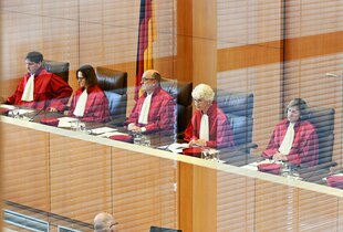 Mehrere Richterinnen und Richter in roten Roben