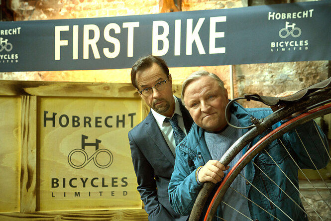 Zwei Männer stehe hinter einem Rad