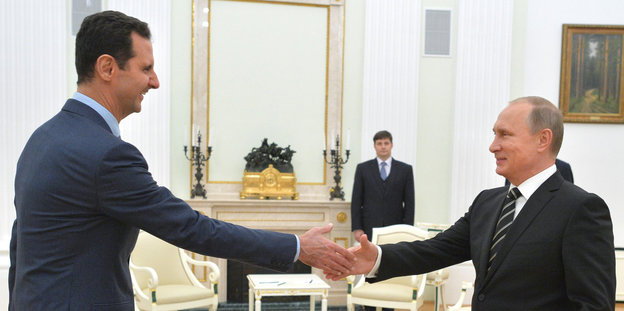 Assad und Putin schütteln sich die Hände.