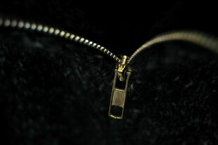 Nahaufnahme eines Reissverschlusses an einem schwarzen Kleidungsstück