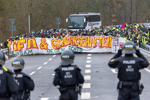 Polizei und Demonstranten stehen sich in Gießen an der Auffahrt der L3047 auf die B429 gegenüber. Auf einem Frontbanner steht: "Antifa & Gewerkschaften - Gemeinsam gegen rechts".