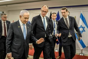 Friedrich Mez geht mit Benjamin Nethanjahu einen Gang entlang, umringt von Mitarbeitern