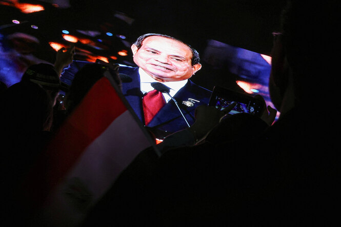 Abdel Fattah El-Sisi blickt aus einem großen Bildschirm, im Vordergrund Zuschauer