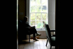 Haus in Chawton von Jane Austen - eine Frau sitzt lesend an einem Fenster mit Blick in den Garten
