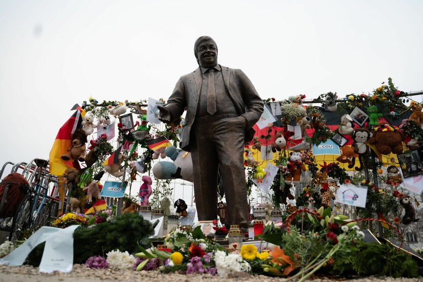 Statue von Walter Lübcke, ringsherum sind Blumen abgelegt