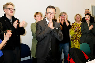 Mann hält sich vor Freude die Hände vors Gesicht