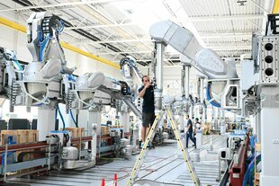 Ein Arbeiter des Maschinenbauers Dürr montiert am Stammsitz einen Roboterarm für eine Lackieranlage für Fahrzeuge